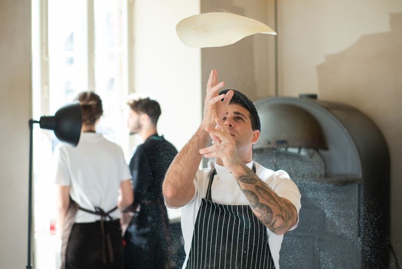 Via 313 team preparing fresh Detroit-style pizza in the kitchen